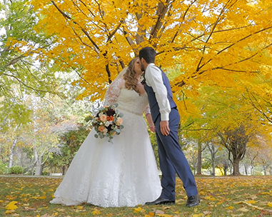 A bride and groom kissing under the tree