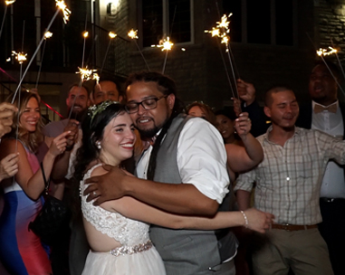 A couple dancing at their wedding with sparklers in the air.