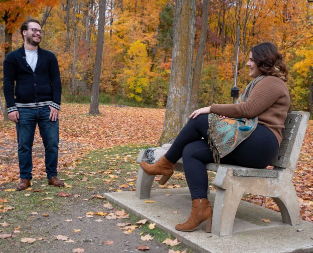 A man and woman sitting on a bench in the park.