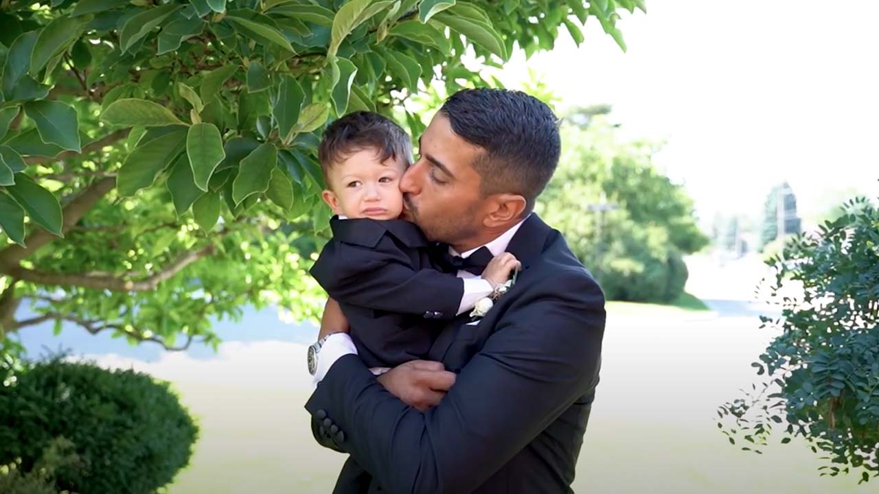 A man in a suit kissing his son.